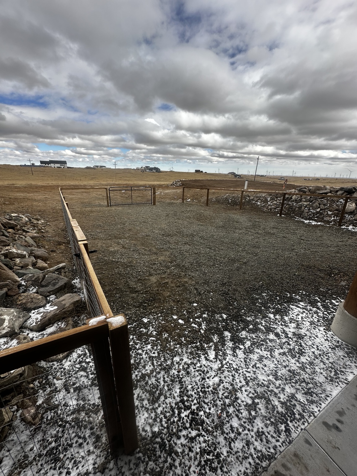 Wire fence enclosure viewed from the gravel patio